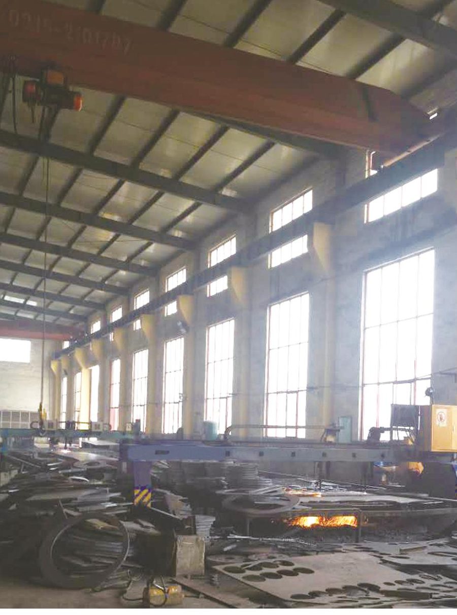 Fabrication workshop interior with overhead cranes and plasma cutting table